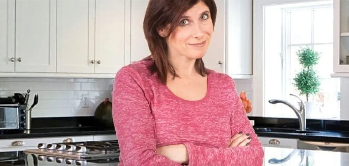 mom smirking and crossing her arms in the kitchen