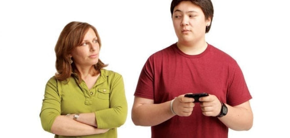 tall teen boy texting and mom frowning at him