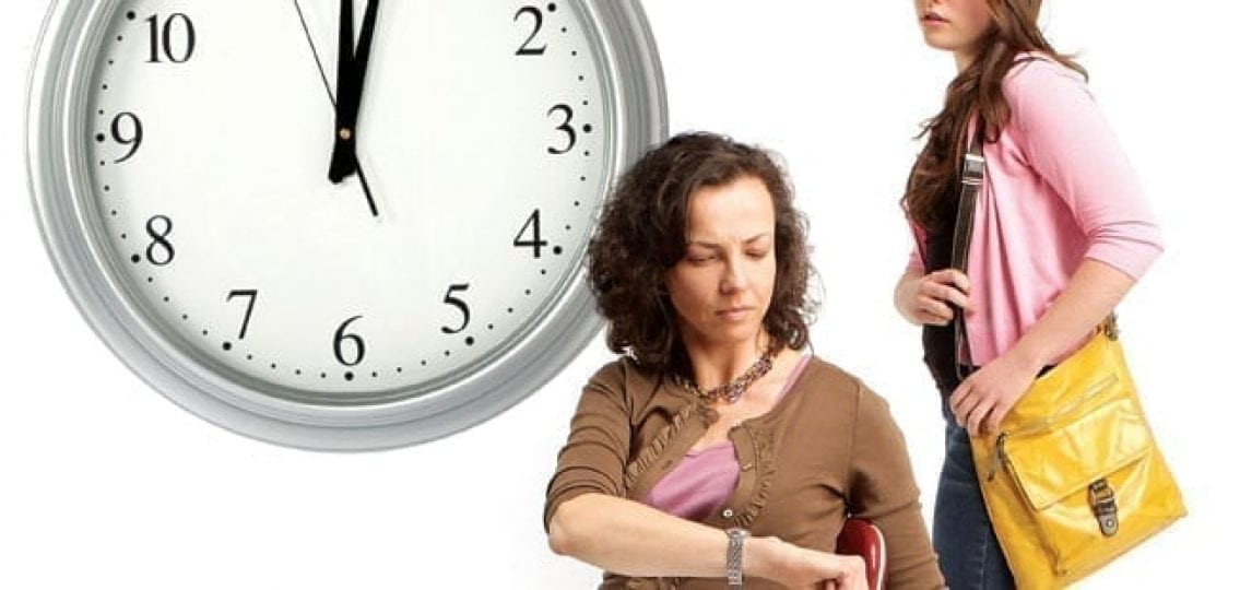 mom looking at watch while daughter leaves house with a clock reading midnight in the background