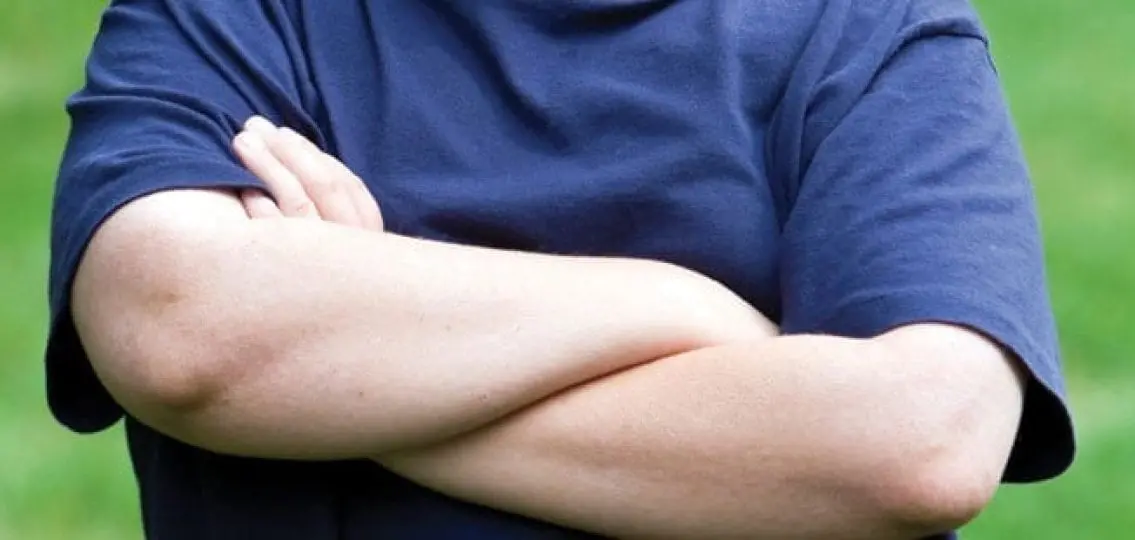 overweight teenage boy crossing his arms close up outdoors