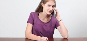 teen girl on a phone call smiling at the camera