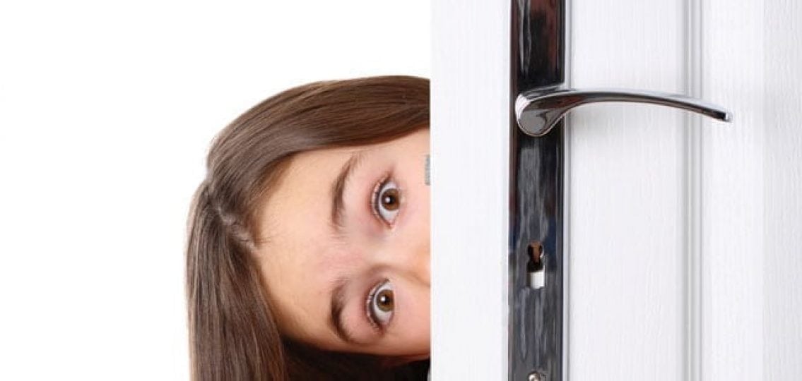 teenage girl peaking around the door