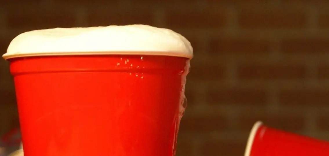a red solo cup with beer foaming at the top