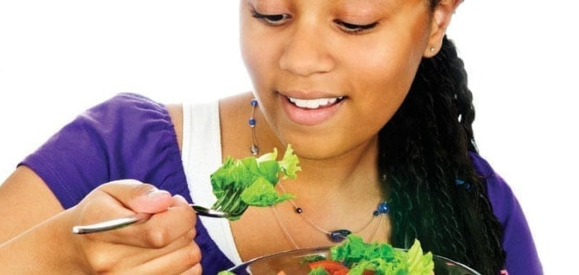 teenage girl eating a healthy salad