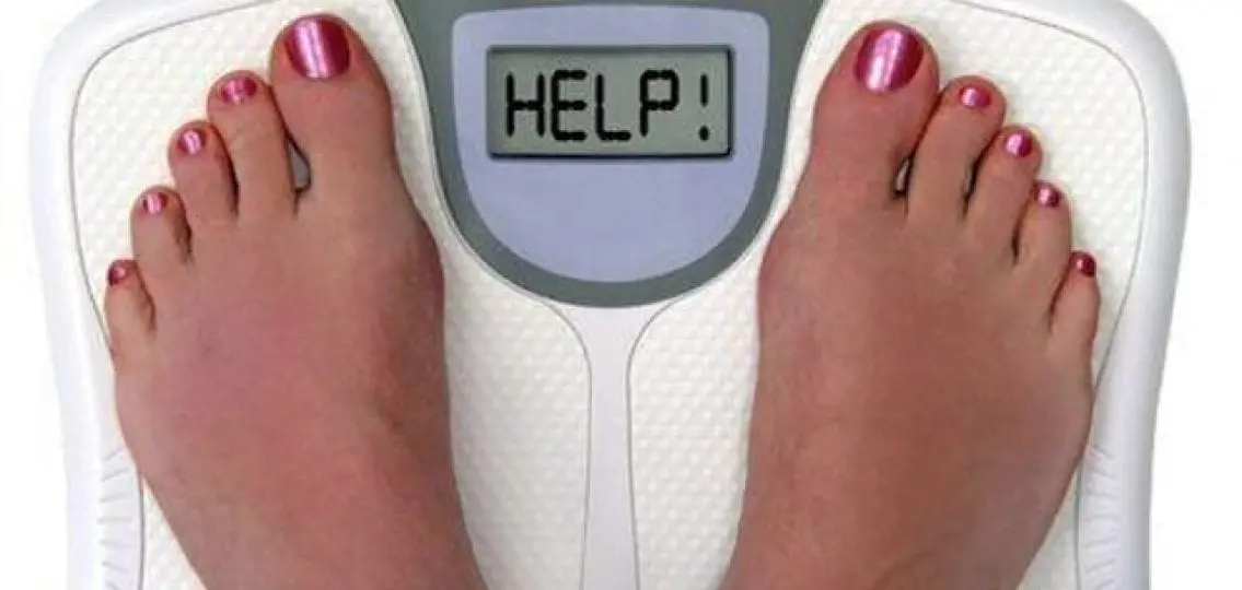 feet with painted nails on a scale that reads HELP!