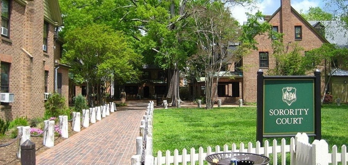 a picture of a quad with dorms and a green sign labeled Sorority court