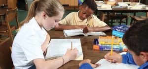 young teenagers studying spanish and PSAT in the library