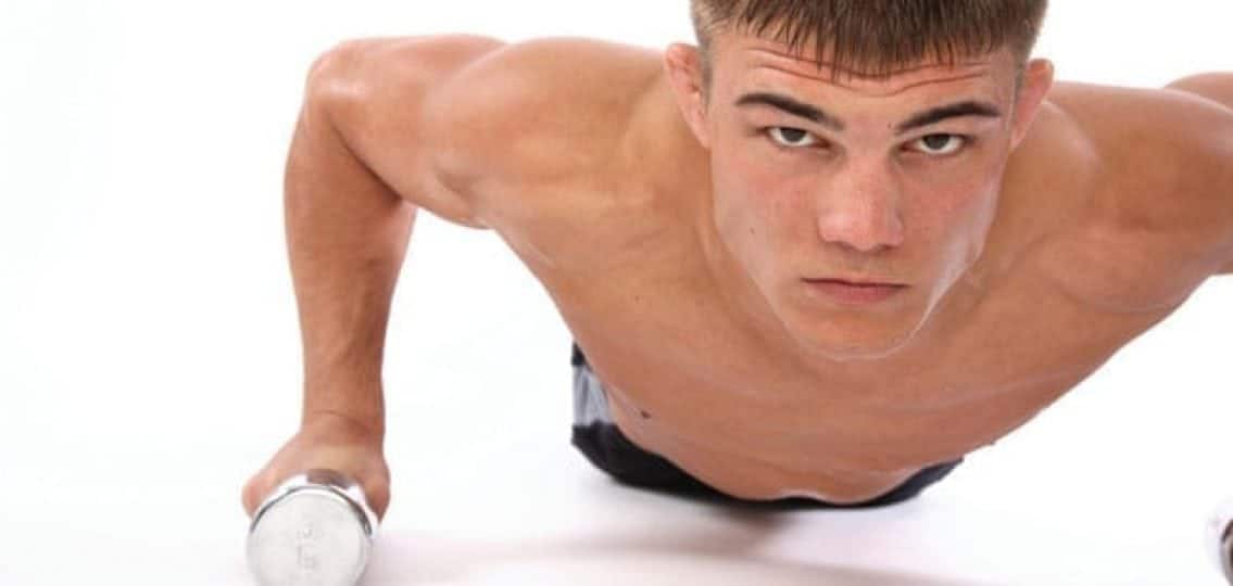 teenage boy exercising doing pushups on a white background