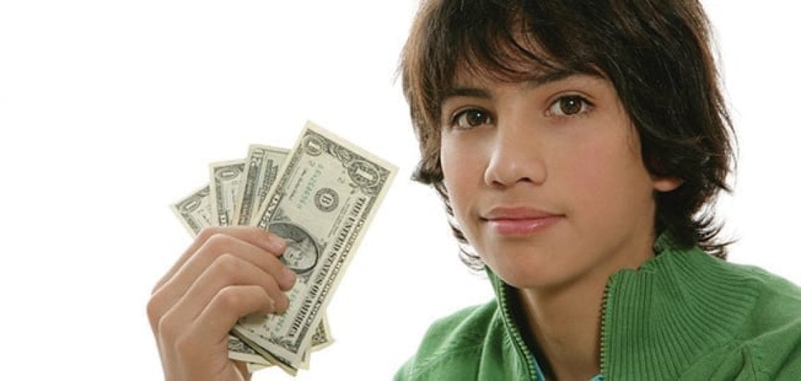 young teen boy holding the money he's saved