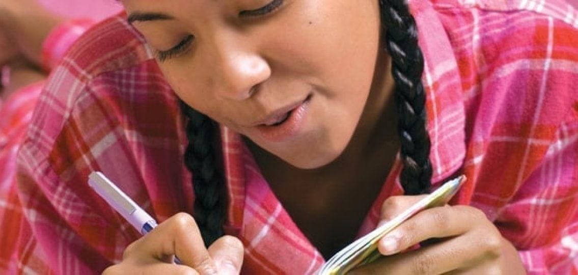 closeup teenage girl writing in her diary
