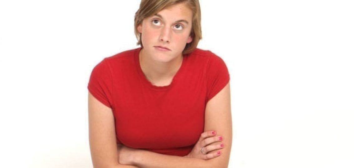 annoyed teen with her arms crossed thinking
