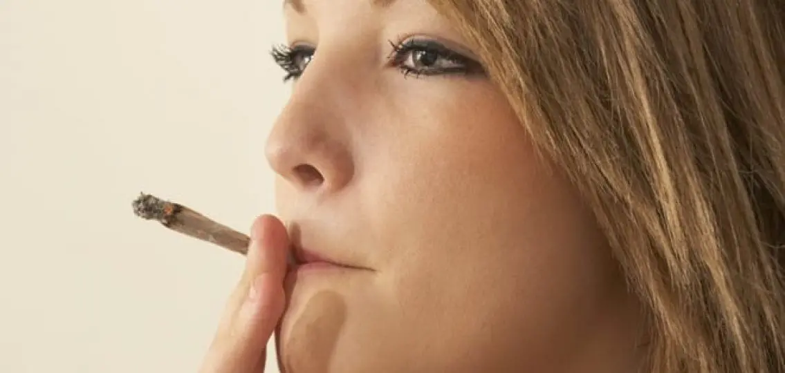 close up of a teenage girl smoking a joint