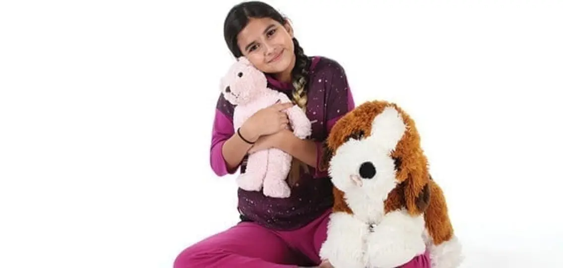 middle school girl hugging large stuffed animals