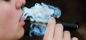 teenager vaping close up breathing out vape smoke