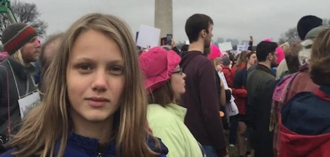teen girl at the woman's march surrounded by other marchers