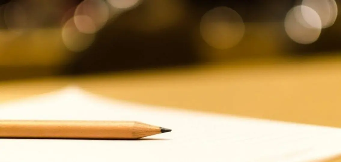 a pencil on a blank piece of paper blurred background