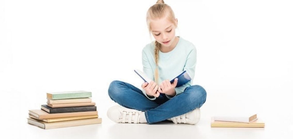 young girl reading books on isolated white background
