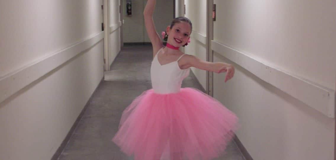 girl in a ballet tutu dancing in a hallway