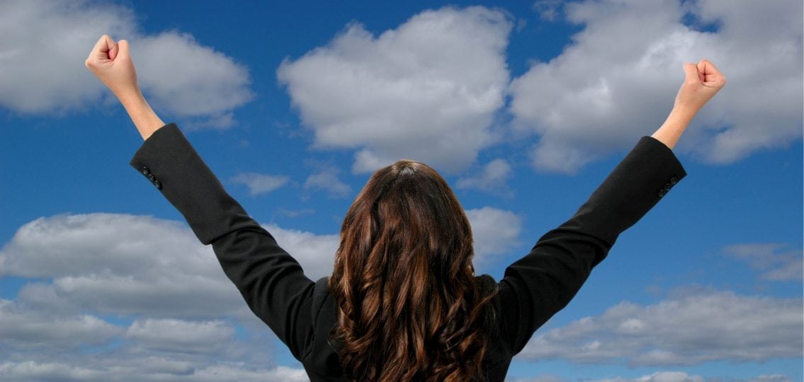 single mom holding up arms and cheering sky background