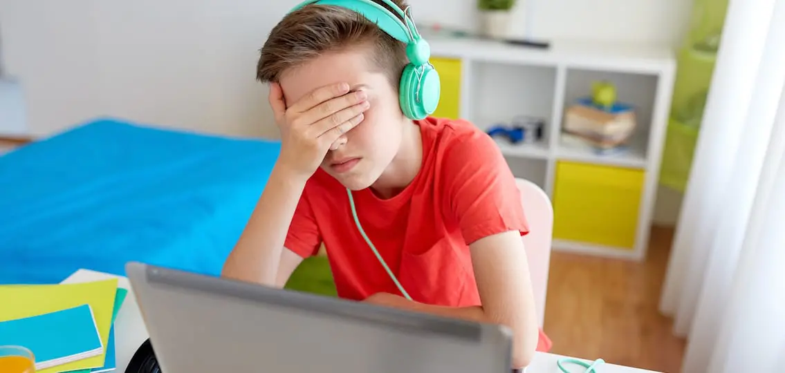 Boy In Headphones Playing Video Game On Laptop