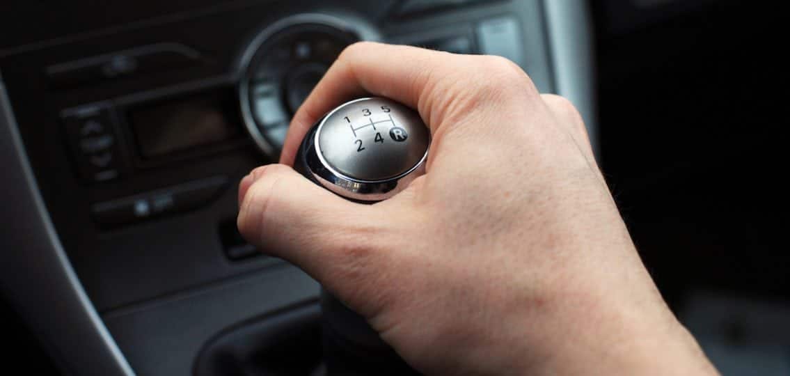 close up of a hand on a manual gear shift knob