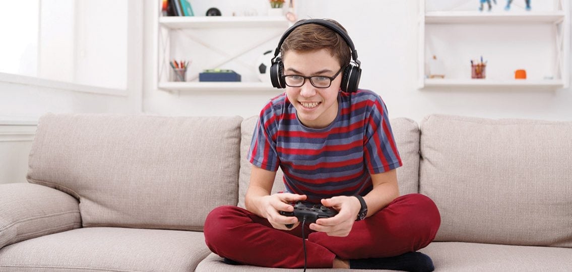 video game fanatic playing a video game in front of a tv on a couch
