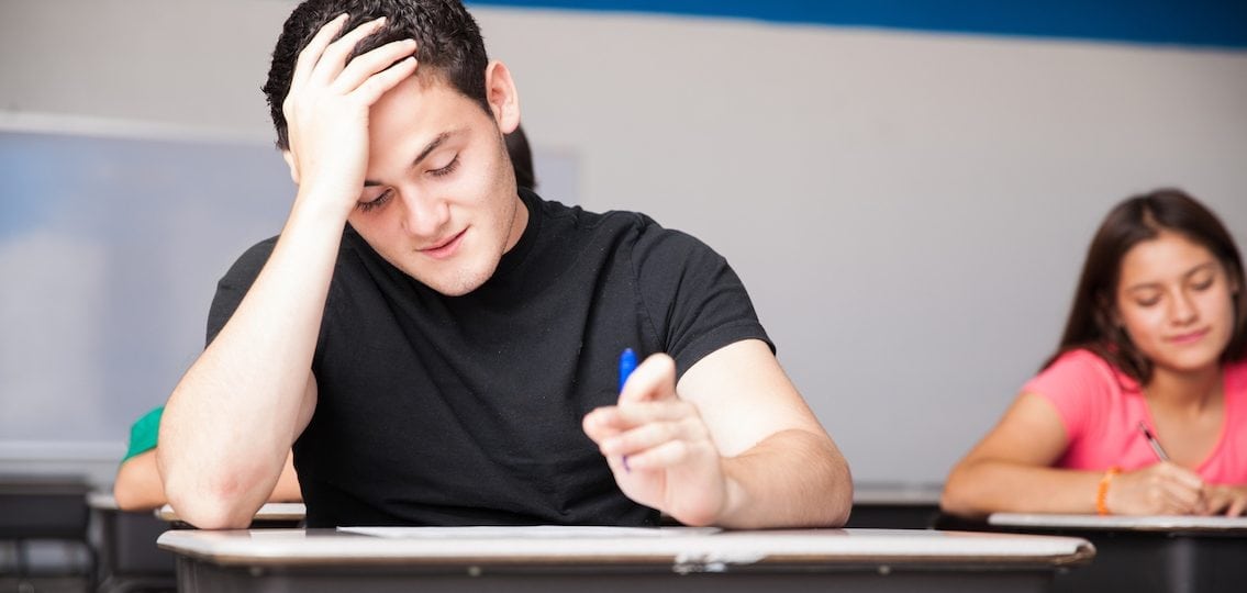 teenage boy stressed out trying to take a test