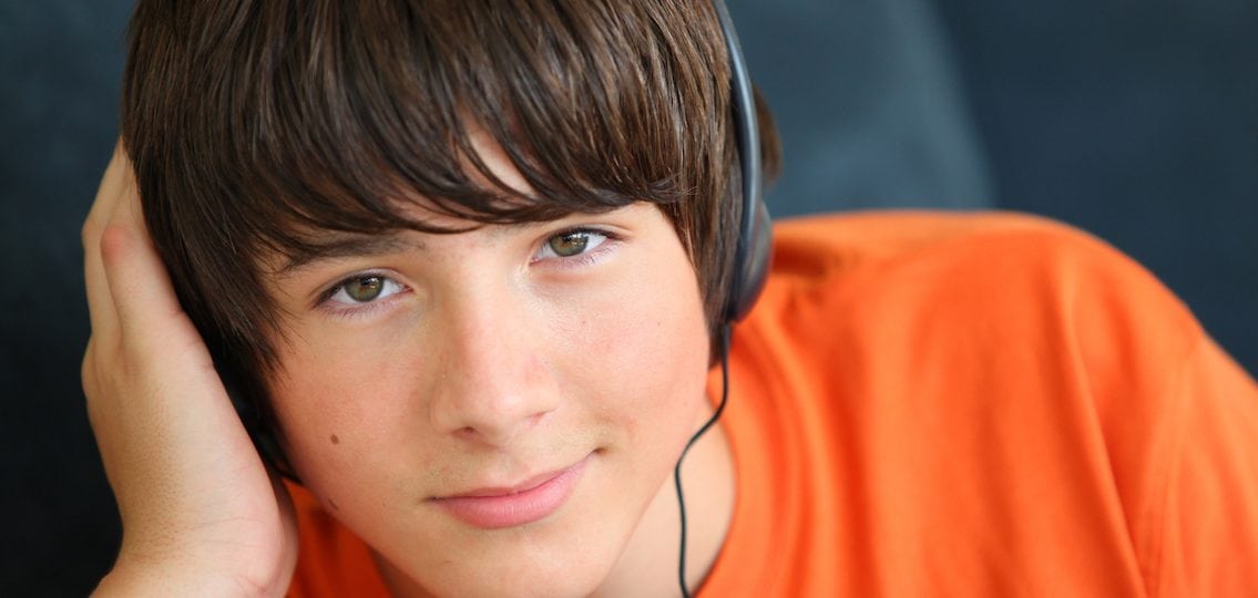teen boy close up wearing headphones listening to music
