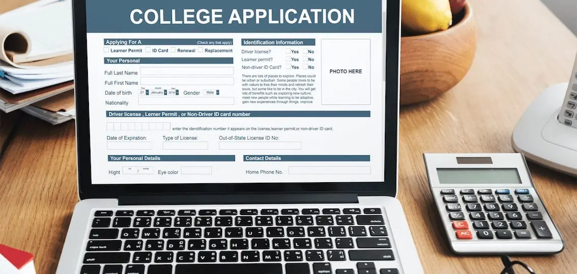 filling out application for college on a laptop with a calculator