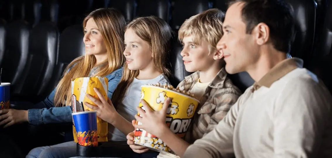 Family Watching Film In Theater with popcorn