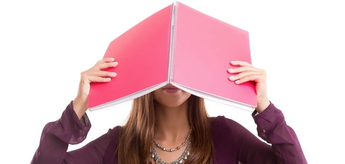 Freshman Covering Face With Journal white background