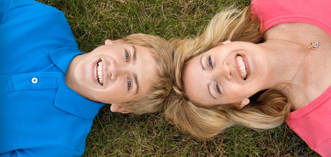 Mom And Son Laughing and lying in the grass bonding