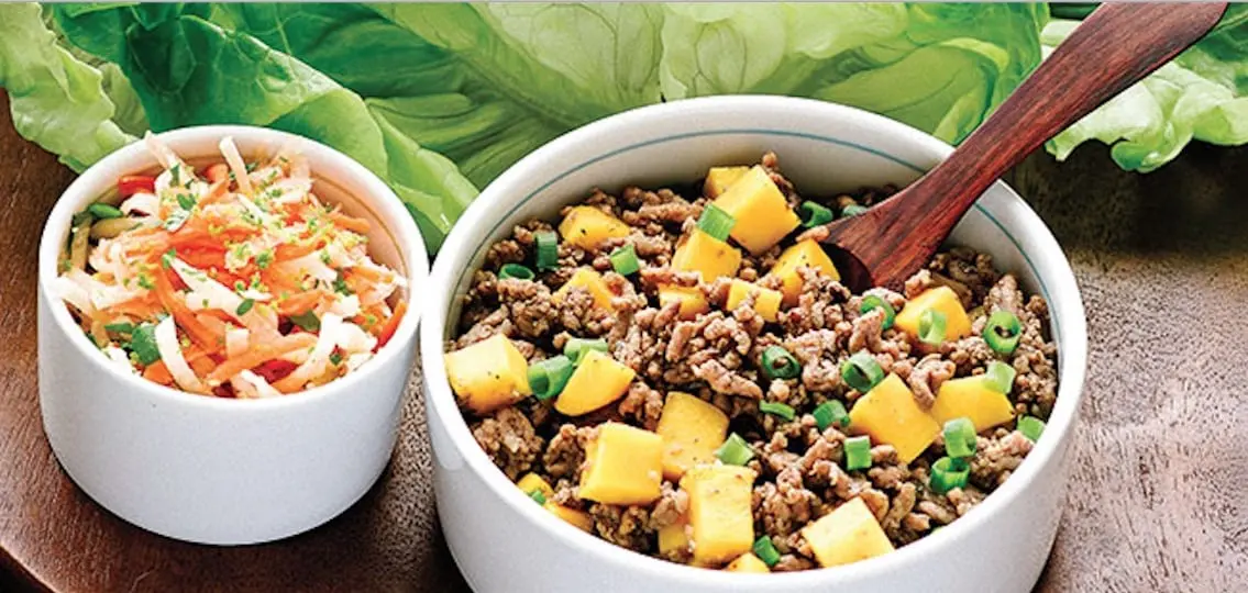 Paleo Taco ingredients: ground beef and veggies with lettuce wraps in the background