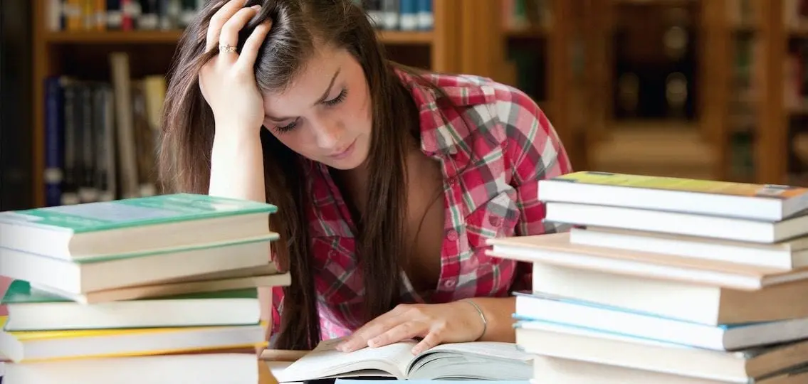 stressed girl college student at library reading looking close to tears