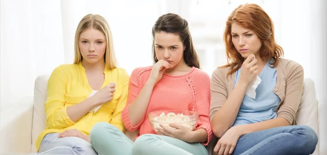 Three Sad Teenage Girl Watching Tv At Home
