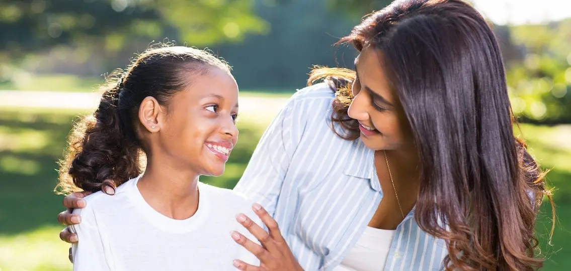 Mother Talking To Daughter and smiling outside