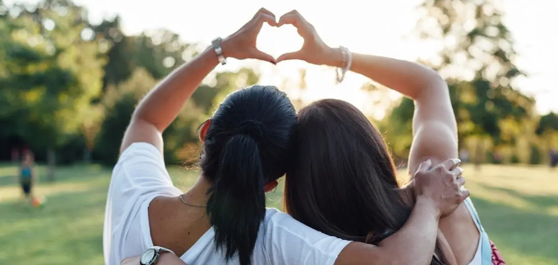 Mom And Daughter Forming A Heart With Their Hands outdoors