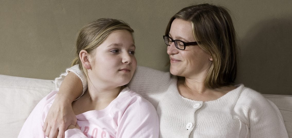 confident parent with her arm around her teenage daughter