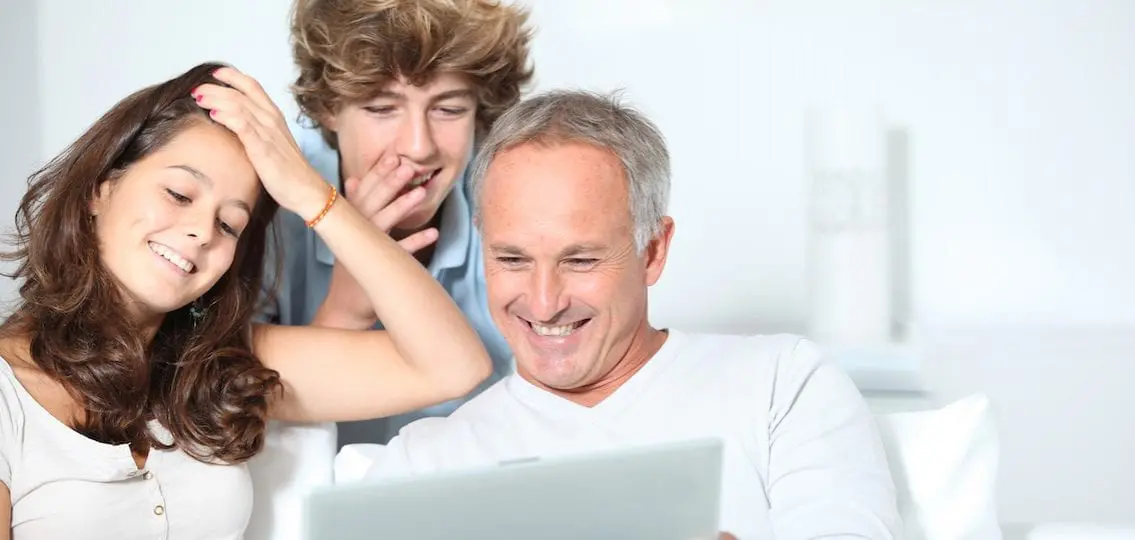 family looking at a laptop together and smiling