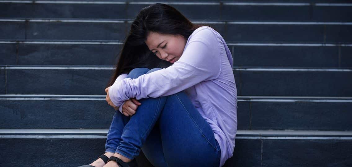 a crying teen girl on the steps with teenage ocd