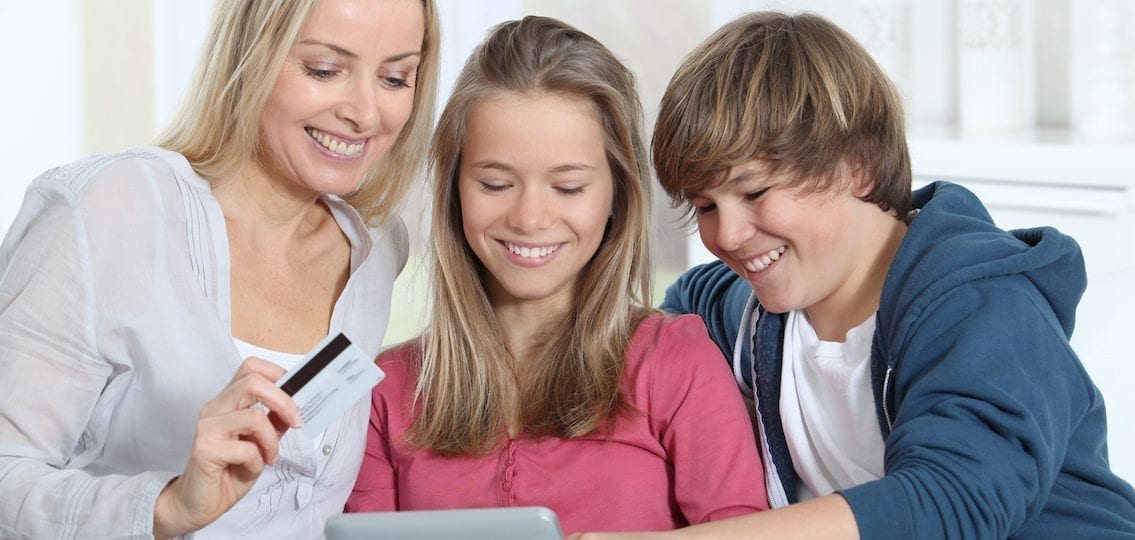 teens and mom with a credit card online shopping