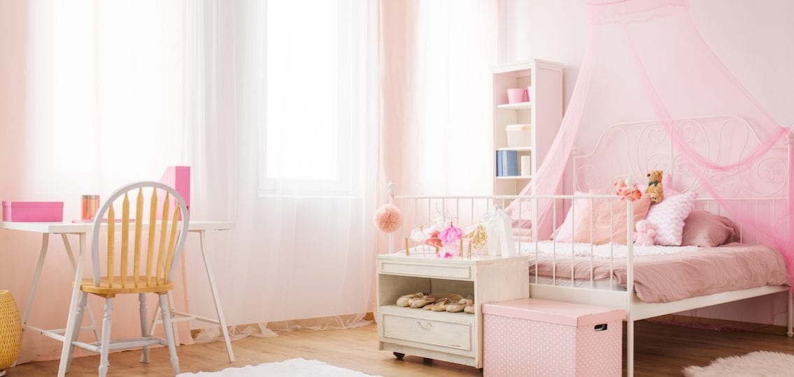 Young girl's bedroom pink walls and bed with curtain