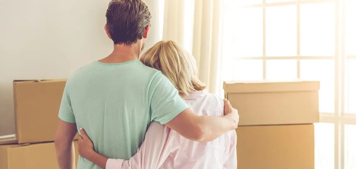 mom hugging teen son who is moving out with moving boxes