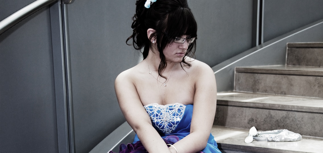 Teenager in prom dress sad