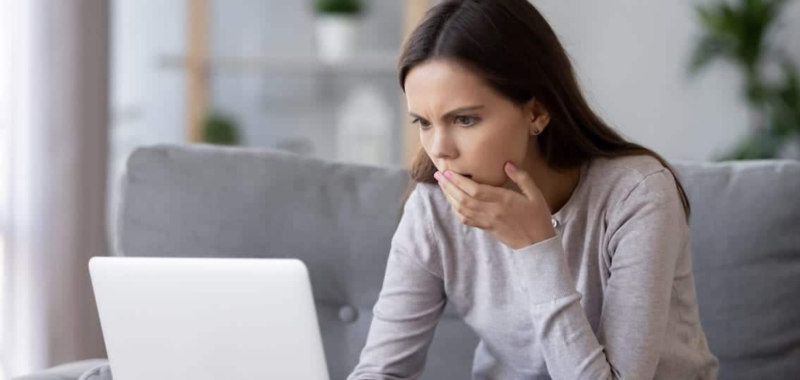 Horrified teen girl on computer covering mouth