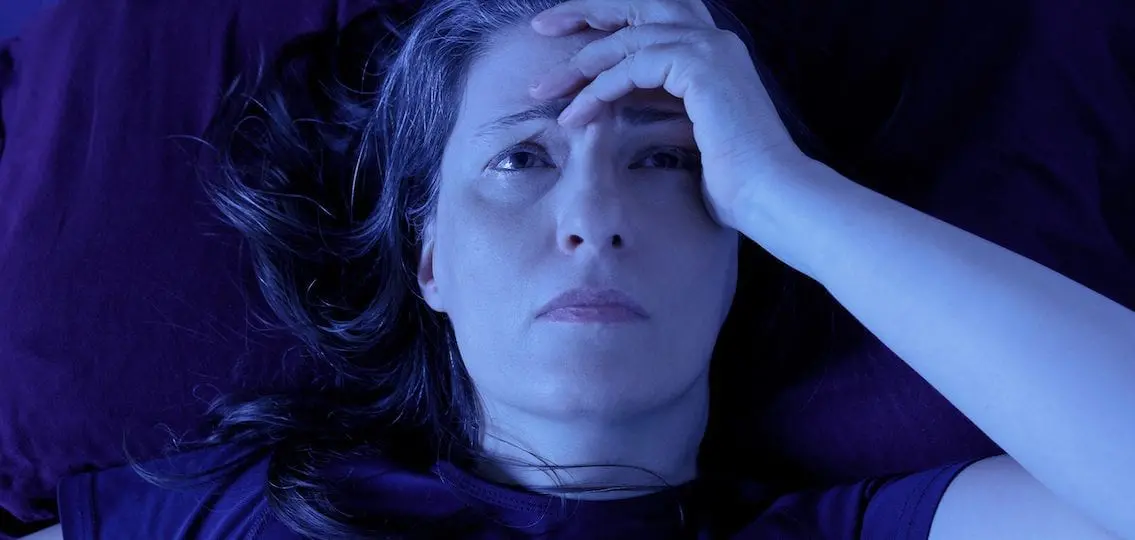 Stressed mother in the dark lying in bed