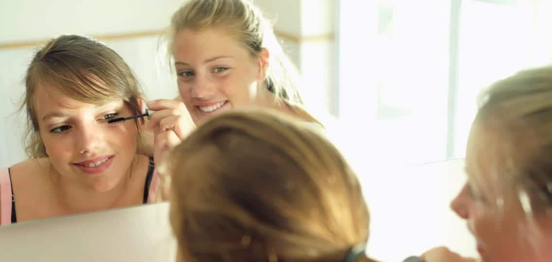 teen Girls doing makeup together and smiling