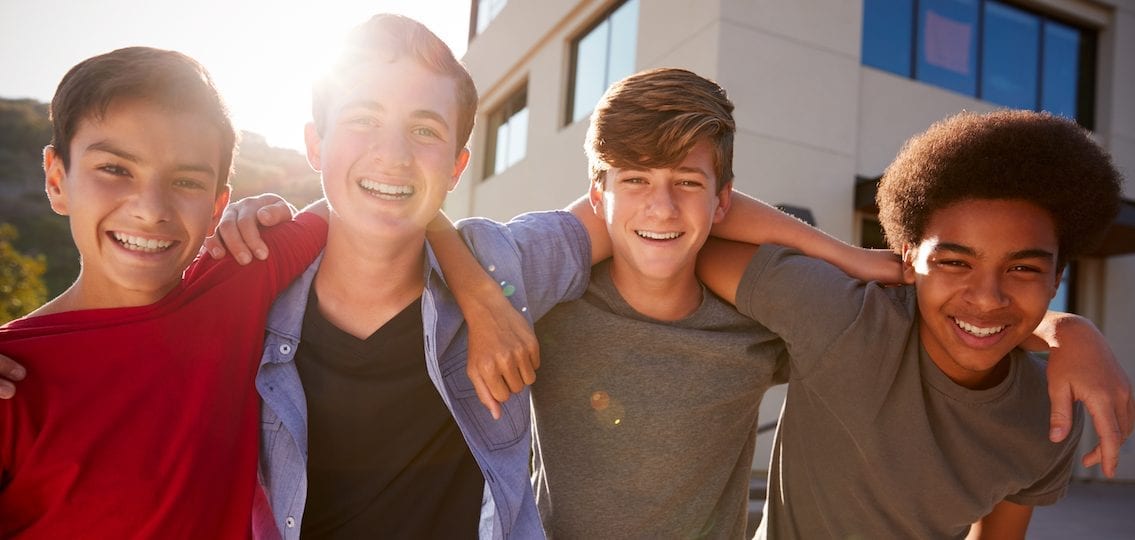 Teen boys hanging out arms over shoulders