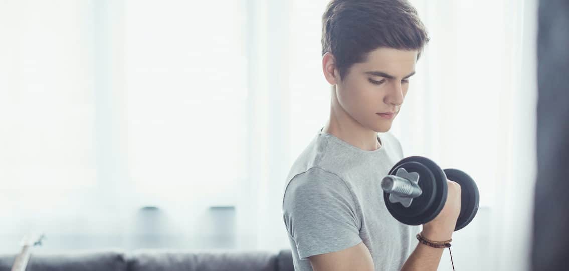 teen boy with body image issues exercising