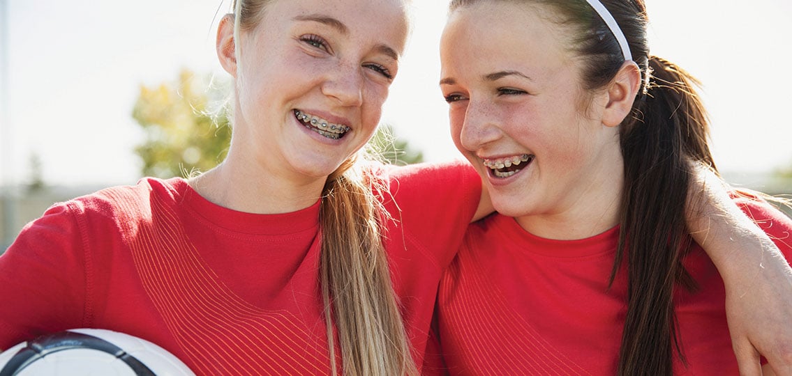 teen Girl Soccer Players With Their Arms Around Each Other.